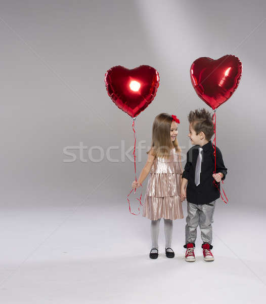Happy kids with red heart balloon on a light background Stock photo © arturkurjan