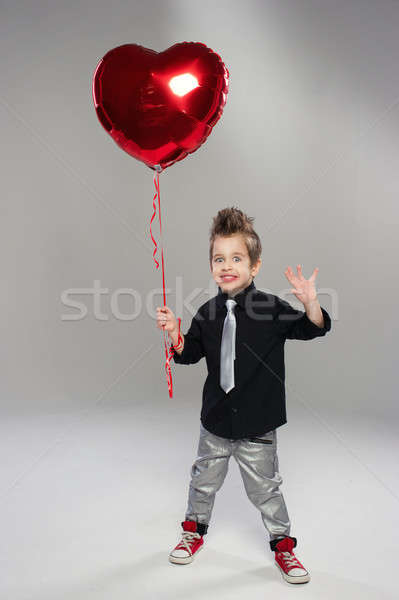 Happy small boy with red heart balloon on a light background Stock photo © arturkurjan