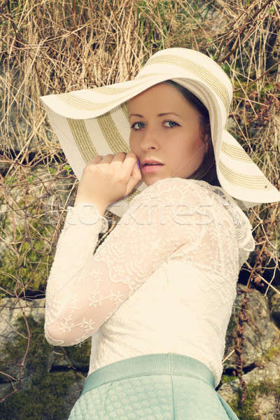 Cheerful fashionable woman in stylish hat and frock posing Stock photo © artush