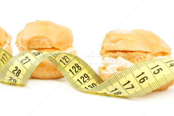 concept of slimming, caramel cakes with measuring tape Stock photo © artush