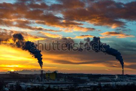 Sunrise silhouette of smoking factory Stock photo © artush