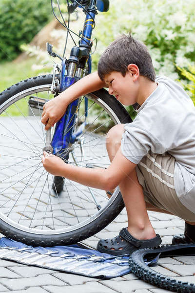 Teenager repairing his bike, changing broken tyre Stock photo © artush