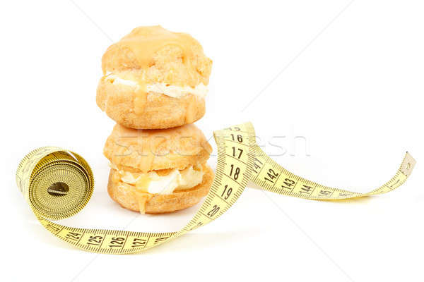 concept of slimming, caramel cakes with measuring tape Stock photo © artush