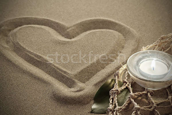 handwritten heart on sand with lighted candles Stock photo © artush