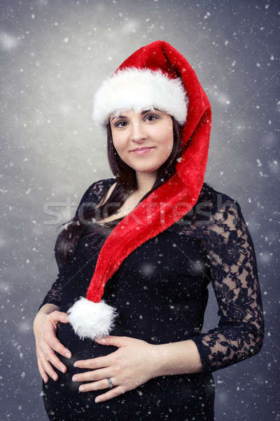 beautiful pregnant santa woman tenderly holding her tummy Stock photo © artush