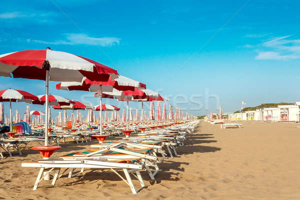 red and white umbrellas and sunlongers on the sandy beach Stock photo © artush
