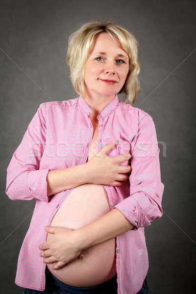 beautiful pregnant woman tenderly holding her tummy Stock photo © artush