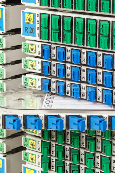 Stock photo: fiber optic rack with high density of blue and green SC connectors