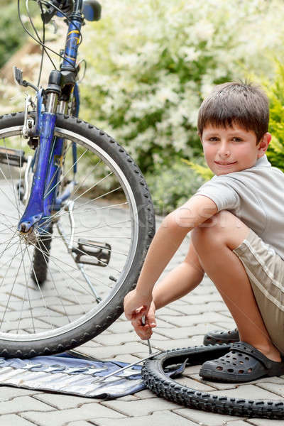 Teenager repairing his bike, changing broken tyre Stock photo © artush