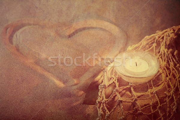 retro toned heart on sand with lighted candles Stock photo © artush