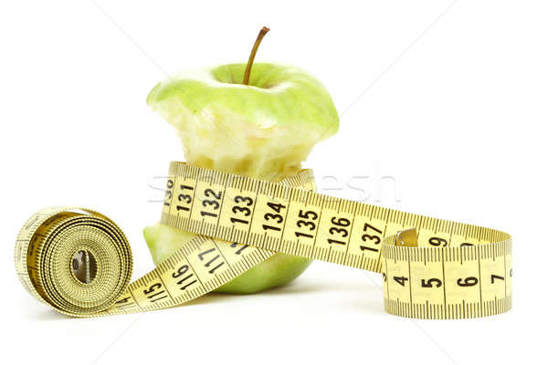 Stock photo: Green bitten apple isolated on white with measuring tape