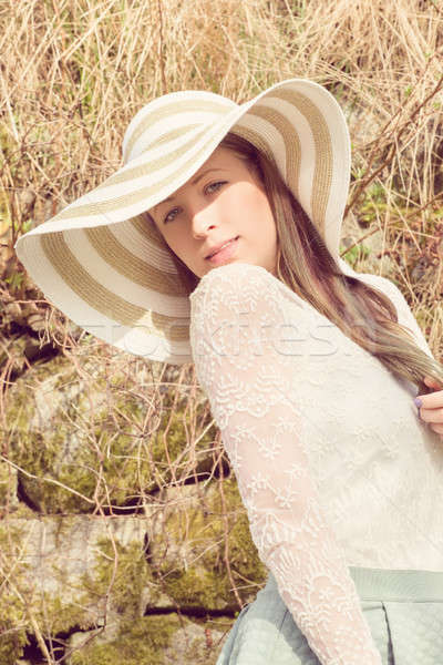 Stock photo: Cheerful fashionable woman in stylish hat and frock posing