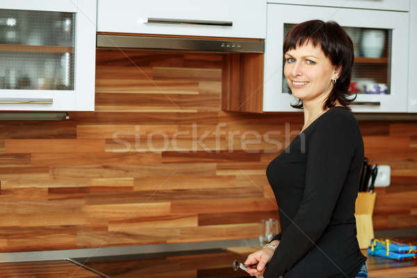 middle-aged woman wipes the dishes in the kitchen Stock photo © artush