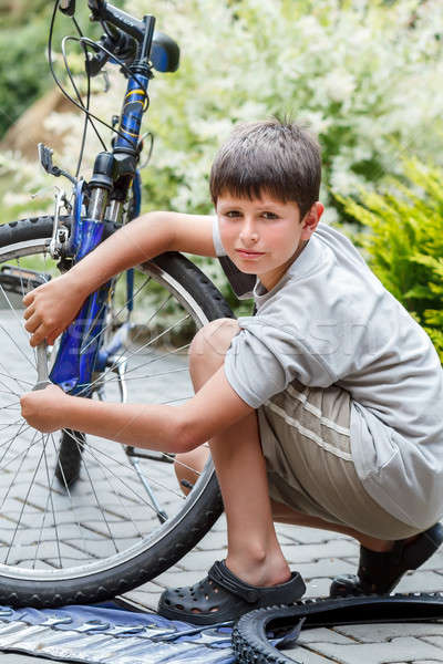 Teenager repairing his bike, changing broken tyre Stock photo © artush