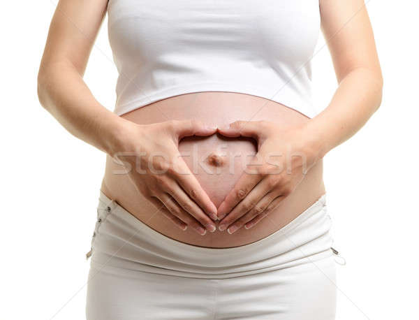 Femeie gravida țin de mâini forma de inima gravidă burtă izolat Imagine de stoc © ashumskiy