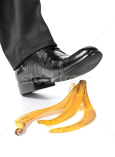 Businessman foot about to slip and fall on a banana peel Stock photo © ashumskiy