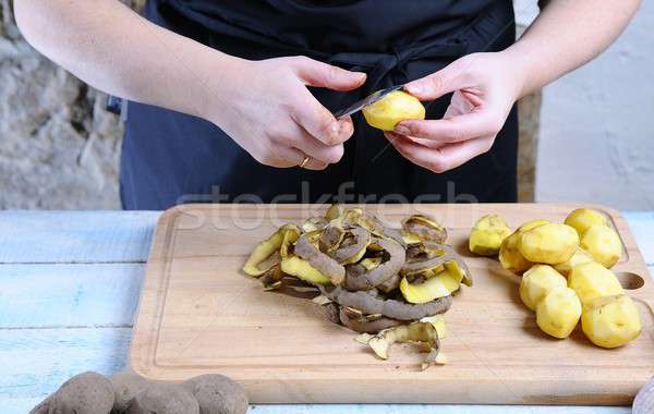 Woman peeling potato with knife Stock photo © asturianu