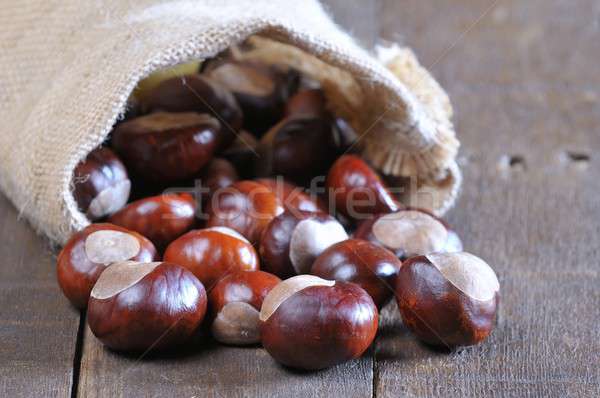 Close-up of chestnuts scattered on wooden table Stock photo © asturianu