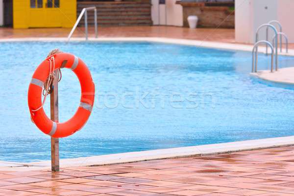 Orange life buoy hanging near swimming pool Stock photo © asturianu