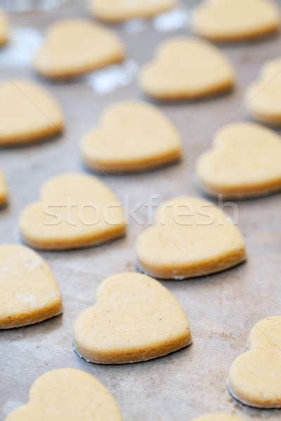 Unbaked heart shaped shortbread cookies on baking tray, selectiv Stock photo © avdveen