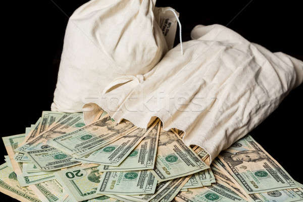 Many US dollar bills or notes with money bags Stock photo © backyardproductions