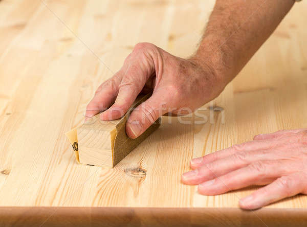 Mans hand on sanding block on pine wood Stock photo © backyardproductions