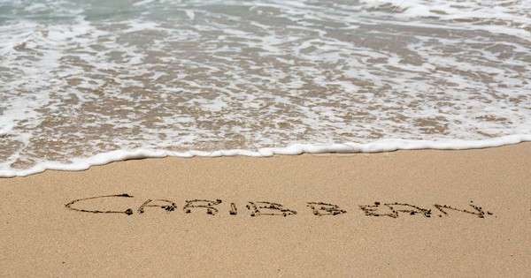 Caribbean written in sand with sea surf Stock photo © backyardproductions