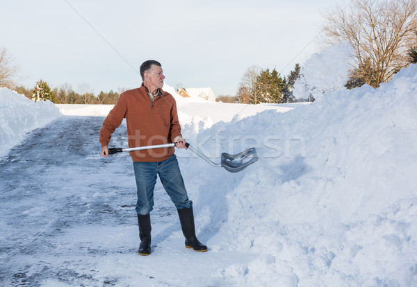 Senior adult man finishes digging out drive in snow Stock photo © backyardproductions