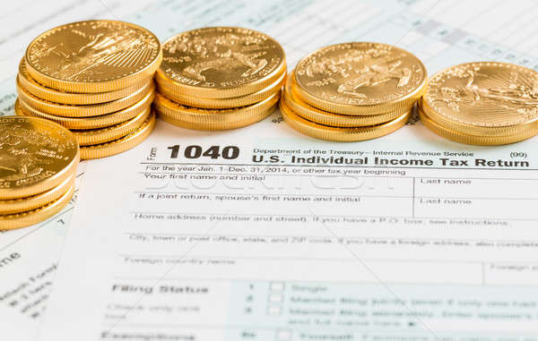 Solid gold coins on 2014 form 1040 Stock photo © backyardproductions