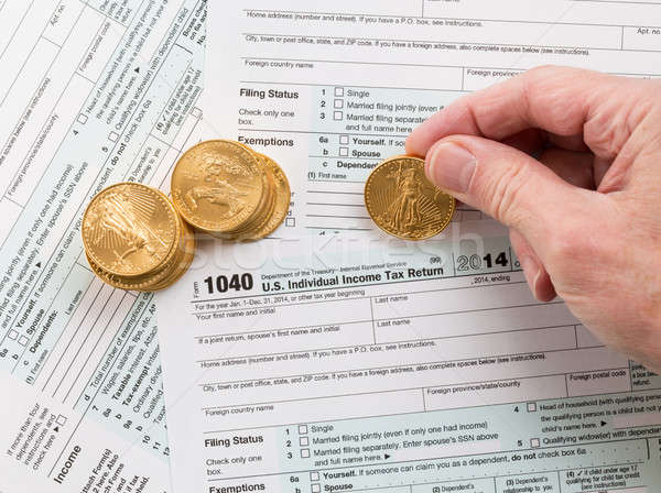 Solid gold coins on 2014 form 1040 Stock photo © backyardproductions