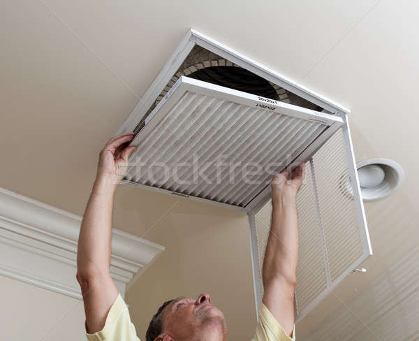Senior man opening air conditioning filter in ceiling Stock photo © backyardproductions
