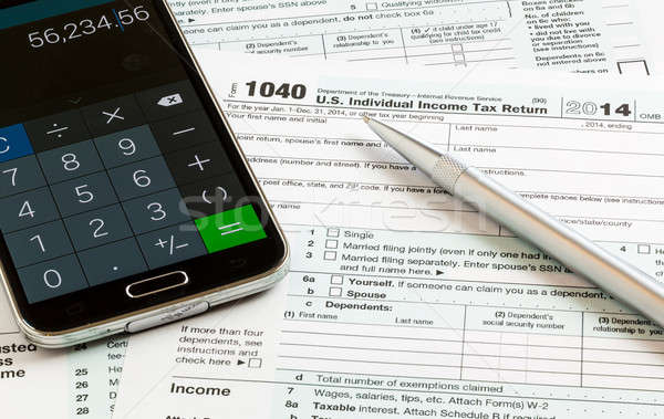 Pen and smartphone on 2014 form 1040 Stock photo © backyardproductions