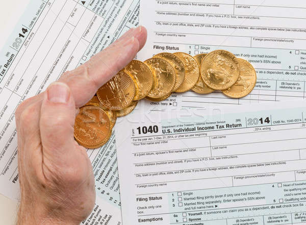 Solid gold coins on 2014 form 1040 Stock photo © backyardproductions