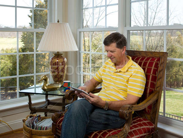 Boomer reading on tablet computer Stock photo © backyardproductions