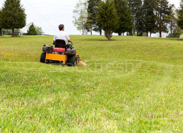 Senior man on zero turn lawn mower on turf Stock photo © backyardproductions