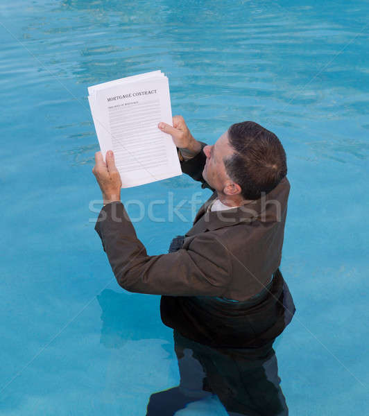Senior man holding mortgage loan document in water Stock photo © backyardproductions
