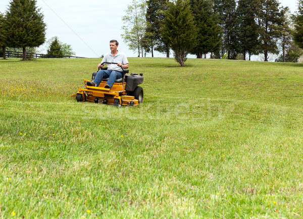 Senior man on zero turn lawn mower on turf Stock photo © backyardproductions