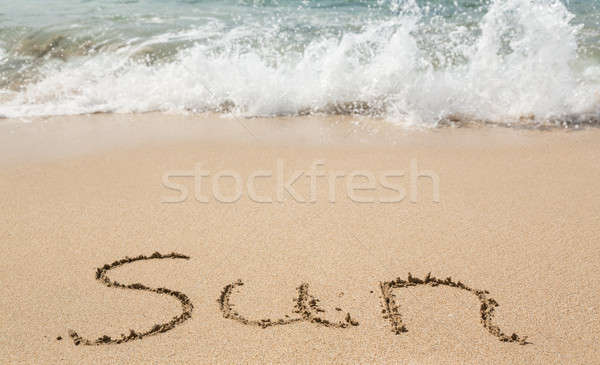 Drawing in sand by ocean of Sun word Stock photo © backyardproductions