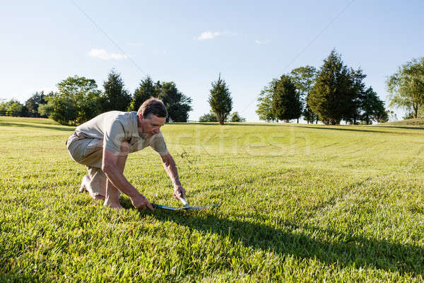 Senior man cutting grass with shears Stock photo © backyardproductions