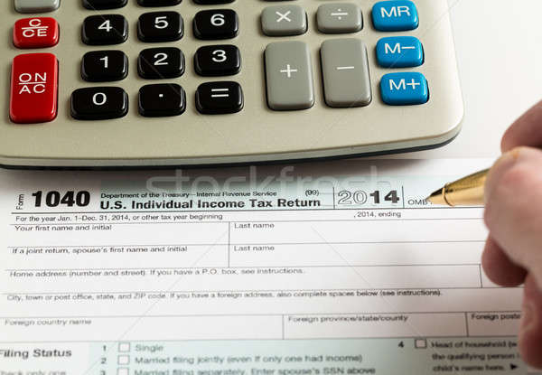 Pen and calculator on 2014 form 1040 Stock photo © backyardproductions