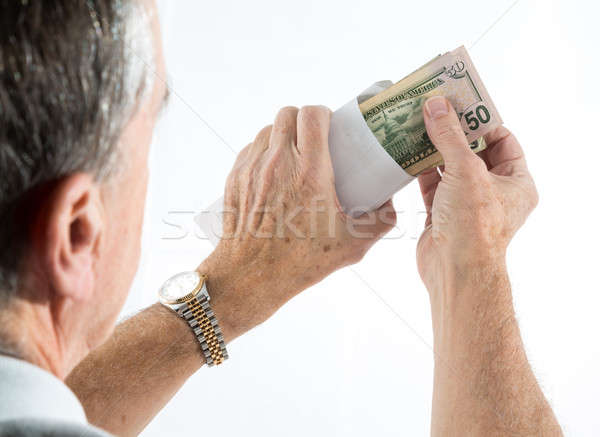 Stock photo: Caucasian ethnicity hands putting fifty dollar bills in envelope