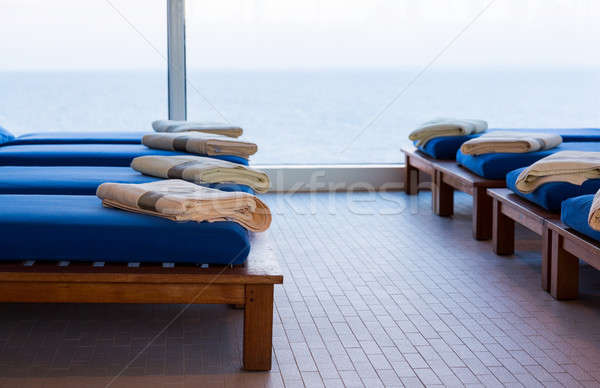 Row of teak cushion bed chairs with towels Stock photo © backyardproductions