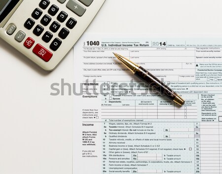 Laptop and calculator on 2015 IRS form 1040EZ Stock photo © backyardproductions