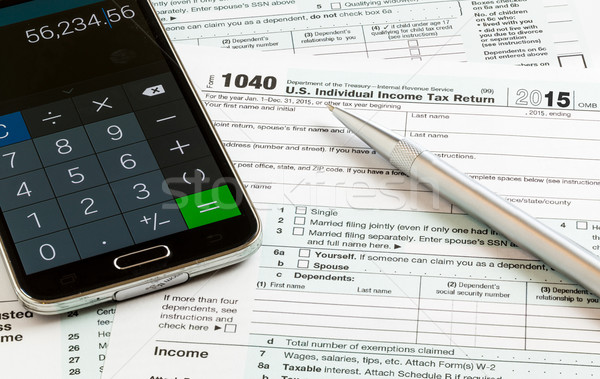 Pen and smartphone on 2015 form 1040 Stock photo © backyardproductions