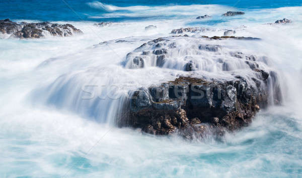 Stock photo: Raging sea flows over lave rocks on shore line