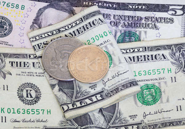 Dollar and half coin on top of bank notes Stock photo © backyardproductions