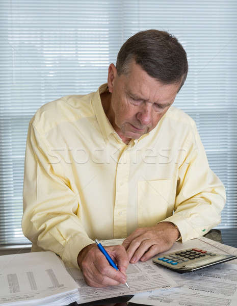 Stock photo: Senior man preparing USA tax form 1040 for 2012