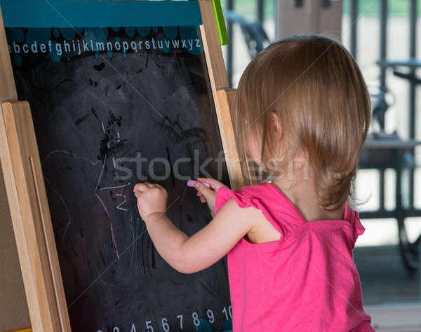 Young baby girl drawing at blackboard Stock photo © backyardproductions