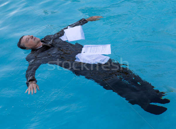 Stock photo: Senior man floating among papers in water
