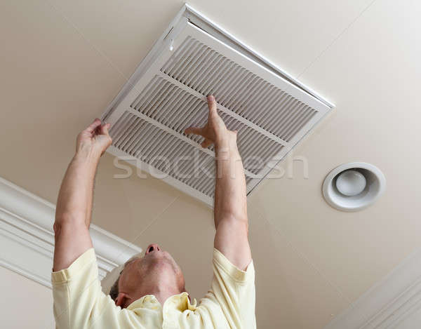 Senior man opening air conditioning filter in ceiling Stock photo © backyardproductions